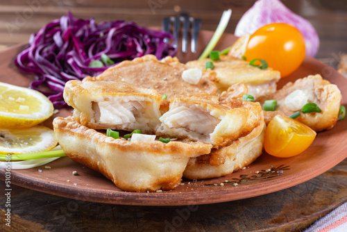 pieces of tilapia fish in cheese batter lightly fried in olive oil. appetizing, tasty healthy food.