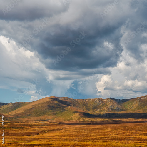 Big storm over the autumn mountain plateau. Big cloud over the autumn valley. Dramatic cloudscape.