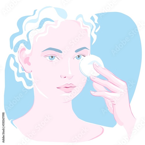 The girl holds a cotton pad in her hand to clean her face.