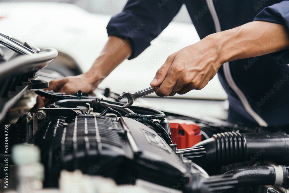 Automobile mechanic repairman hands repairing a car engine automotive workshop with a wrench, car service and maintenance,Repair service. Automobile mechanic repairman hands repairing a car engine automotive workshop with a wrench, car service and maintenance,Repair service.