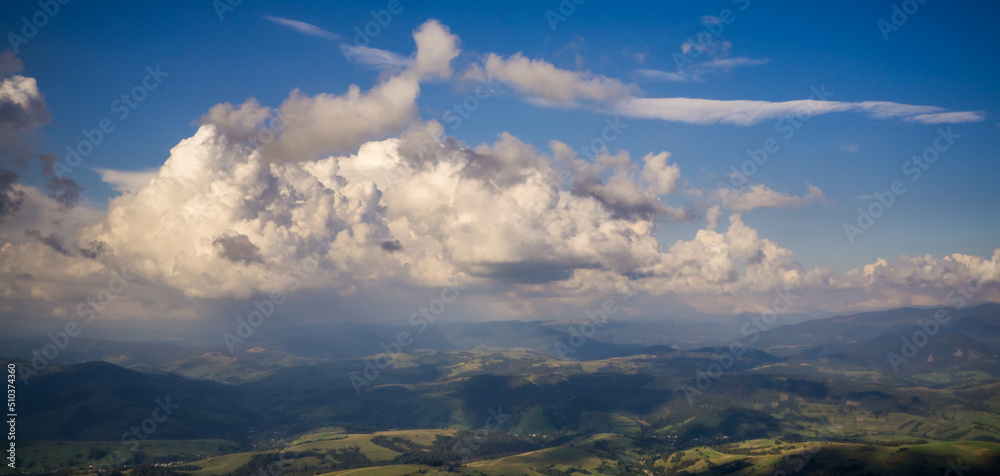 Cumulus clouds over summer mountain valleys.