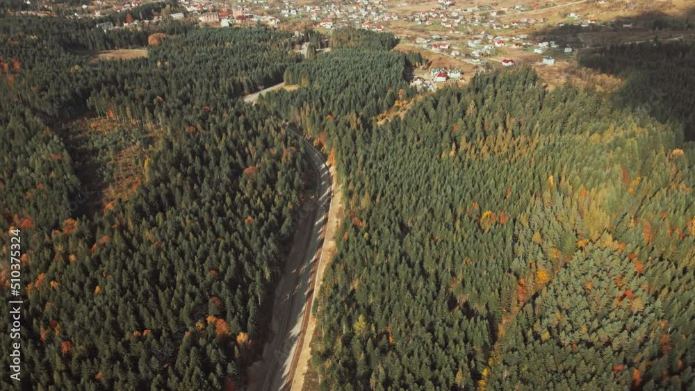 Aerial Drone View: Flight over pine tree forest and country road. Mountain village vith houses in background. Nature, travel, holidays. Carpathians, Ukraine, Europe. Camera go up. 4K motion Aerial Drone View: Flight over pine tree forest and country road. Mountain village vith houses in background. Nature, travel, holidays. Carpathians, Ukraine, Europe. Camera go up. 4K motion