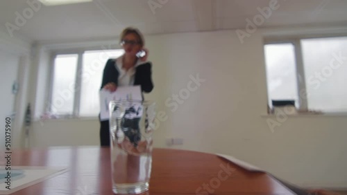 An earthquake shakes an office with water on a table at a business meeting presentation
