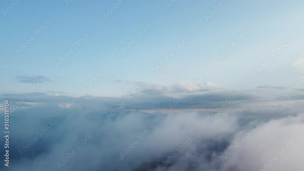 Aerial view. Blue sky sun and fog over calm sea. The drone flies over foggy and fluffy clouds. Abstract aerial nature summer ocean sunset sea and sky background. Vacation, travel and holiday concept. Aerial view. Blue sky sun and fog over calm sea. The drone flies over foggy and fluffy clouds. Abstract aerial nature summer ocean sunset sea and sky background. Vacation, travel and holiday concept.
