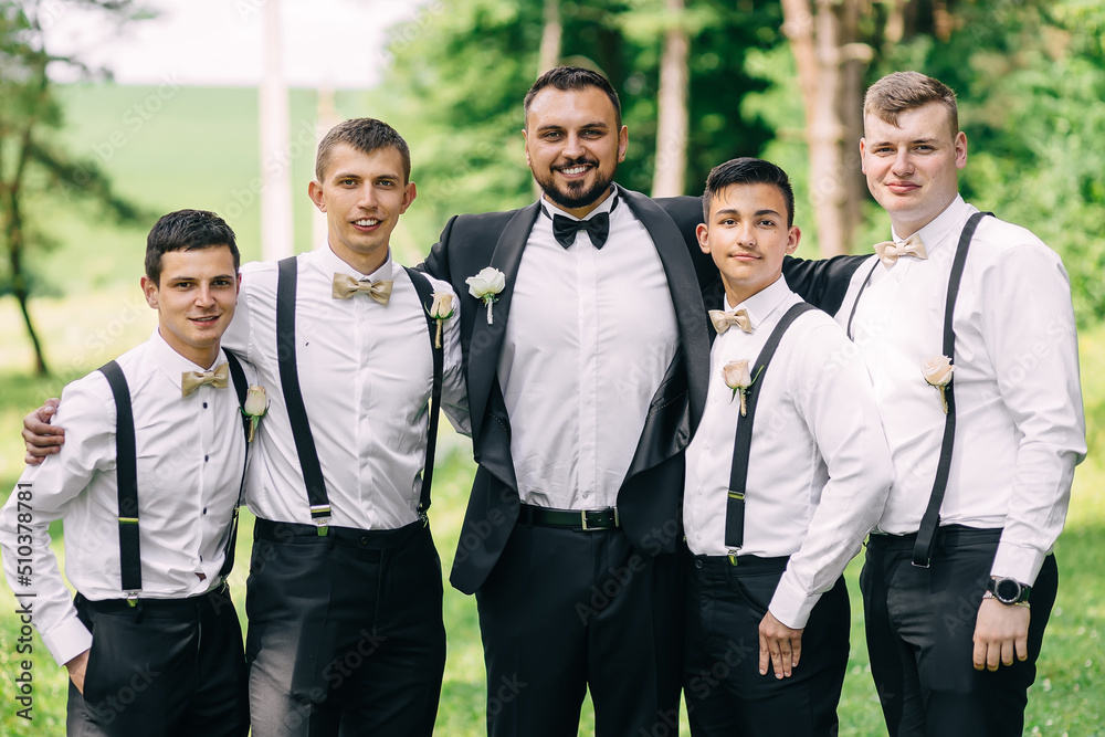 handsome groom with friends in the garden after the wedding ceremony handsome groom with friends in the garden after the wedding ceremony