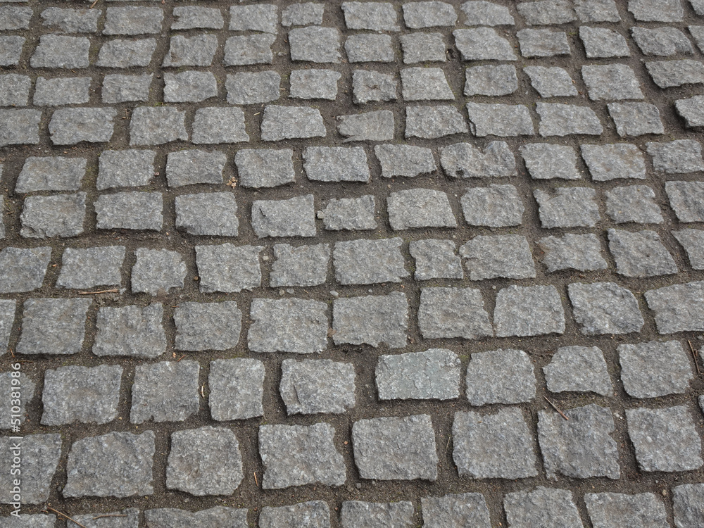 A fragment of a street lined with rows of cobblestones. A fragment of a street lined with rows of cobblestones.