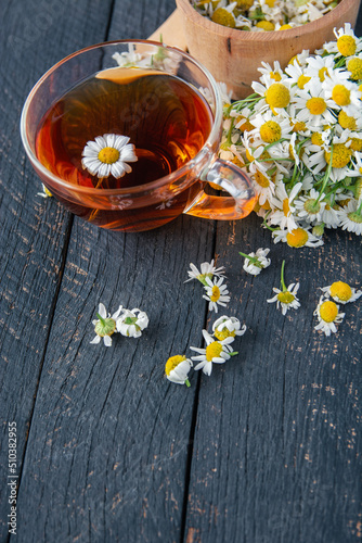 cup of herbal chamomile tea and daisy tea bags and fresh flower  