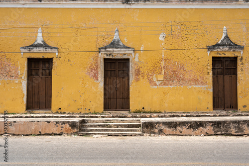 Street in Muna, Yucatan, Mexico with yellow wall and doors photo