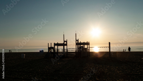 Playground equipment  family on the beach at sunrise