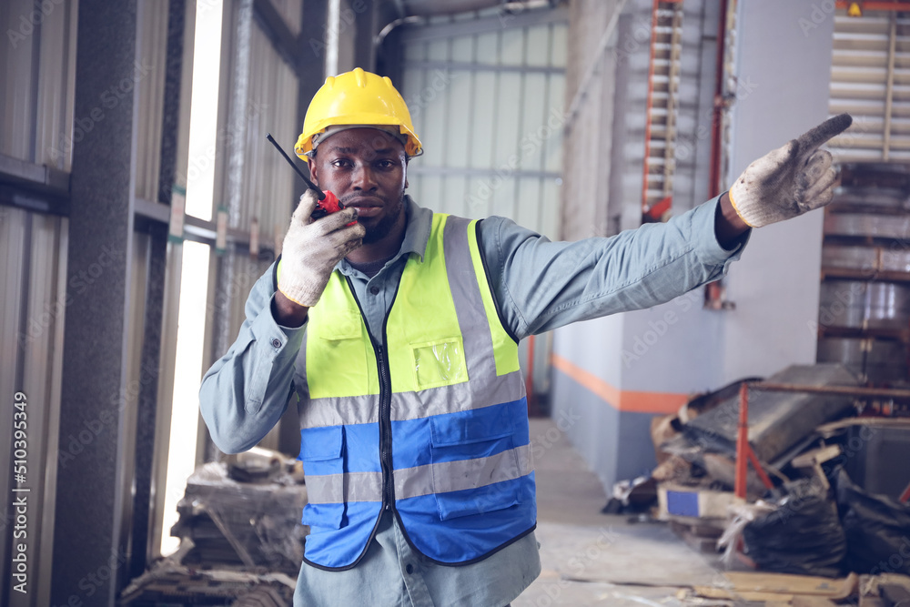 A portrait of technician working or operating in metal factory while radio communication with operator A portrait of technician working or operating in metal factory while radio communication with operator