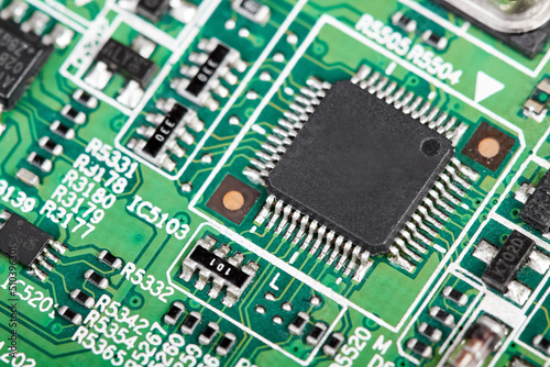 Close-up of a green computer printed circuit board with selective focus on a chip