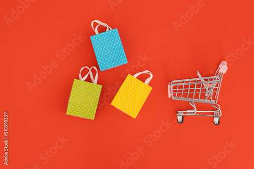Mini shopping trolley on red background
