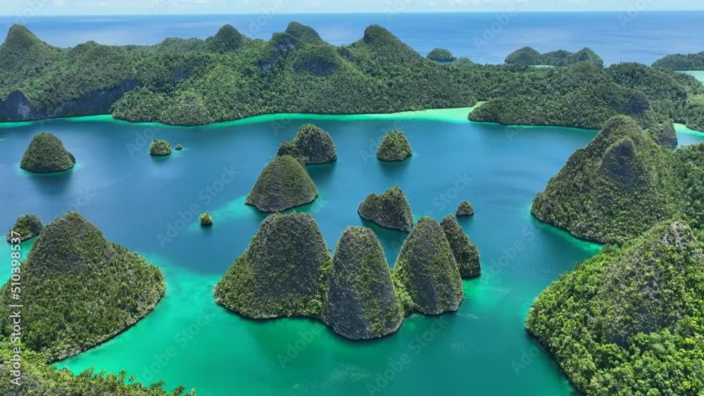 Aerial view of scattered islands with blue ocean water at Wajag Island, Raja Ampat, West Papua, Indonesia.