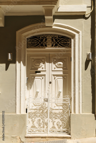 Details of mediterranean architecture. Beige door with post hole, lace lattice photo