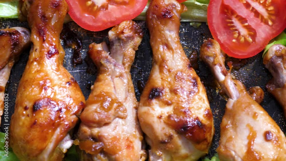 appetizing fried chicken and fresh chopped tomatoes with herbs.fried chicken legs with crispy crust.macro. barbecue grill cooking meat.selective focus appetizing fried chicken and fresh chopped tomatoes with herbs.fried chicken legs with crispy crust.macro. barbecue grill cooking meat.selective focus