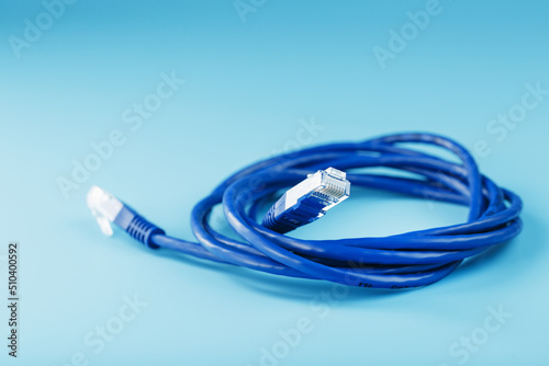 Blue Ethernet Cable Cord Patch cord on a blue background with free space photo