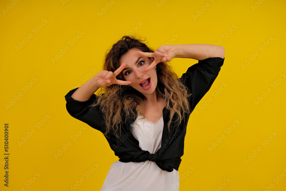 Close-up portrait of a beautiful girl on a yellow background. woman shows joy. positive human emotions Close-up portrait of a beautiful girl on a yellow background. woman shows joy. positive human emotions