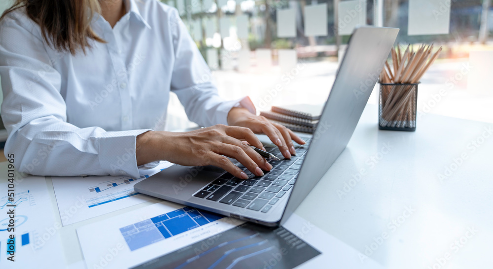 business woman using laptop at office. Male hands typing on the notebook keyboard.Concept of young people work mobile devices business woman using laptop at office. Male hands typing on the notebook keyboard.Concept of young people work mobile devices