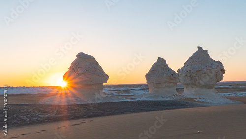 Sunset in the white desert in Egypt, with amazing white rock formations and the sun setting
