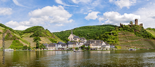 The beautiful village Beilstein in the Moselle valley on a sunny summer day. On a hill above the village are the ruins of Castle Metternich. photo