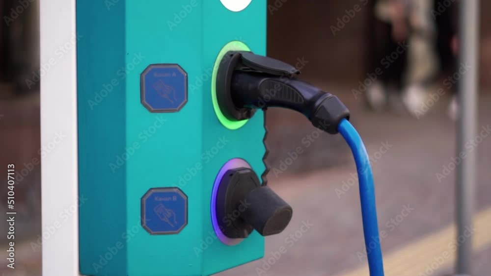 Close up of a device for charging electric cars. Renewable energy. Saving ecology. Electric car charger at the parking Close up of a device for charging electric cars. Renewable energy. Saving ecology. Electric car charger at the parking