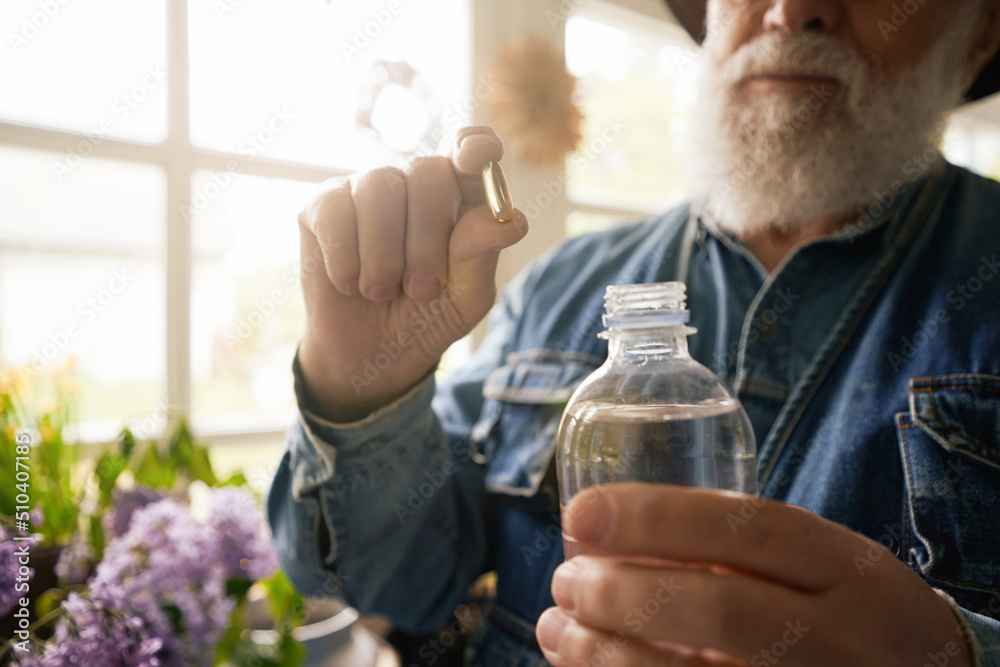 Aged florist preparing fertilization for pot plants Aged florist preparing fertilization for pot plants