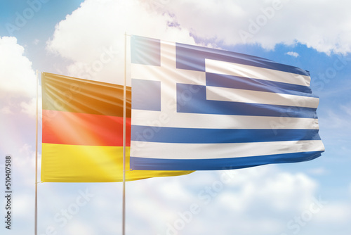 Sunny blue sky and flags of greece and germany