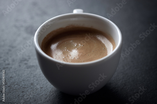 Cup of coffee on dark stone background. Close up. Copy space.