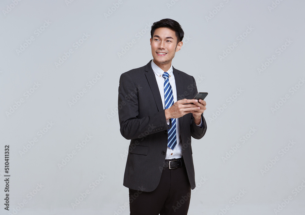 Handsome and friendly face asian businessman smile in formal suit his using smartphone on white background studio shot. Handsome and friendly face asian businessman smile in formal suit his using smartphone on white background studio shot.