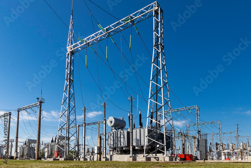 High voltage power transformer substation against the blue sky.