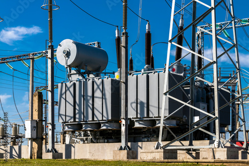 High voltage power transformer substation against the blue sky.