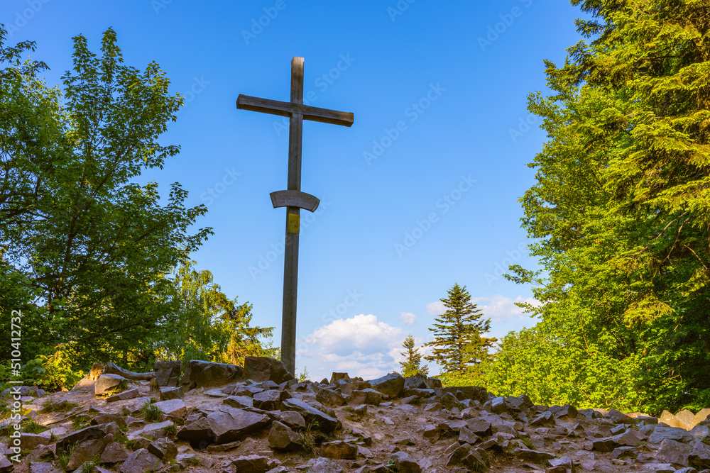 Lysica Mount peak with memorial cross near Swieta Katarzyna village and Bodzentyn at tourist path across Swietokrzyskie Mountains in Poland - obrazy, fototapety, plakaty 