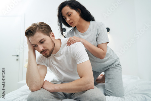 Woman in love massaging shoulders of her upset life partner