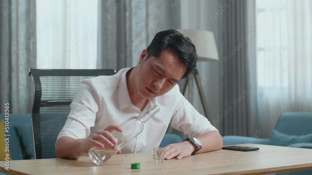 Drunk Asian Man With Smartphone On Table Pours Vodka In A Shot Glass And Cheers Before Drinking At Home
Drunk Asian Man With Smartphone On Table Pours Vodka In A Shot Glass And Cheers Before Drinking At Home