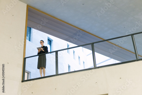 Business woman using tablet pc in minimalist office interior