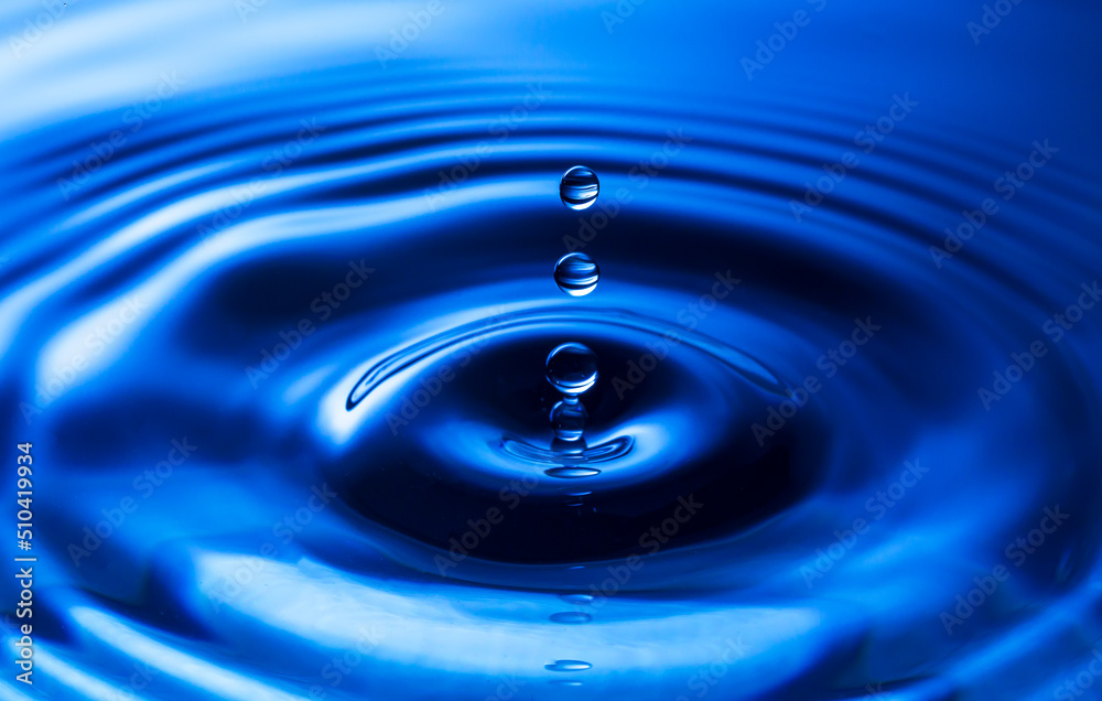Macro water drop,The water droplets fall on the water surface until the water spread out, creating beautiful ripples on the light blue water Macro water drop,The water droplets fall on the water surface until the water spread out, creating beautiful ripples on the light blue water