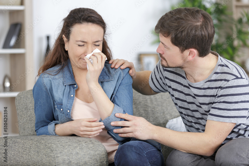 man comforting woman crying on the sofa man comforting woman crying on the sofa