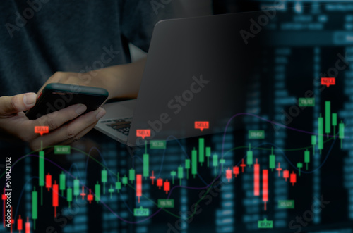 businessman using mobile phone and computer to find financial information. Candlesticks and graphs of the stock market economy.Virtual screen business concept.