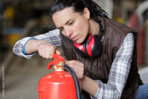 woman is looking at fire extinguisher
