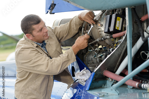 man working on an aircraft using a spanner photo