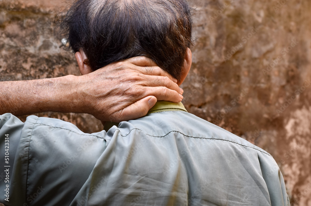 Pain in the shoulder muscle of Southeast Asian man. Concept of nape pain and nuchal stiffness. Pain in the shoulder muscle of Southeast Asian man. Concept of nape pain and nuchal stiffness.