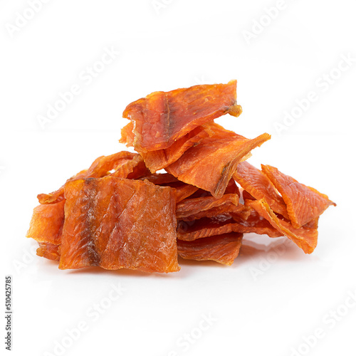 Pieces of salted dried fish with spices on a white background, an appetizer for beer.
