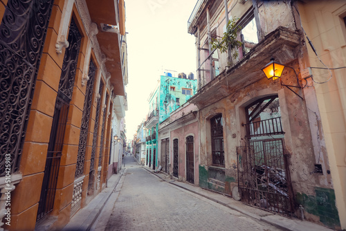 Street scene with classic old cars and traditional colorful buildings in downtown Havana.