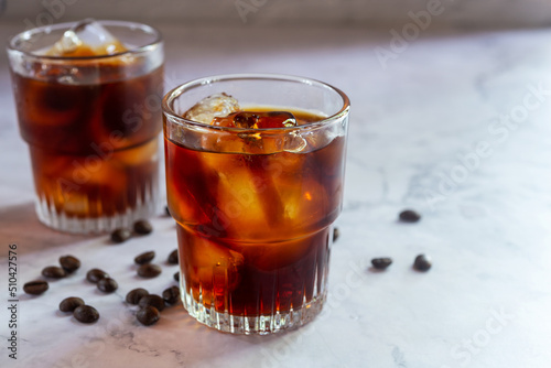 glasses of homemade cold brew coffee with cied on white table background.