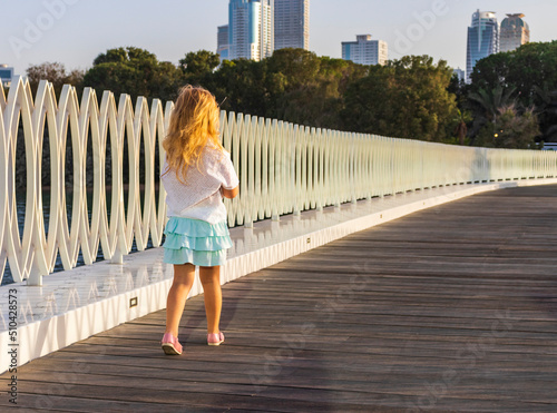 Little girl walking on a board walk. Outdoors