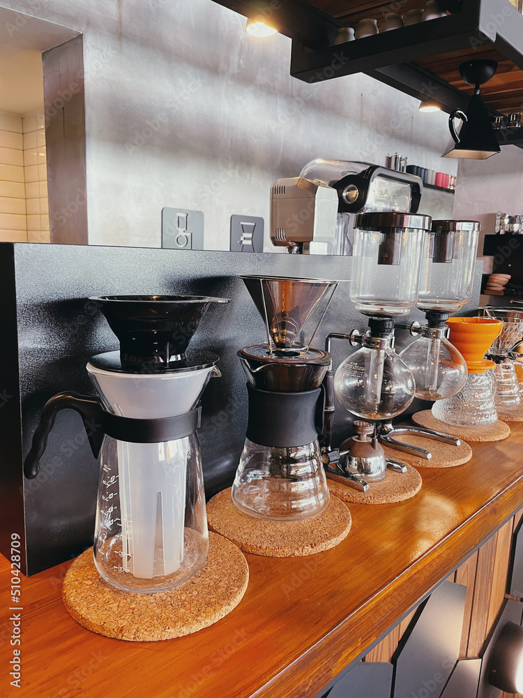 Siphon vacuum coffee makers on cafe bar. Coffee's devices and pots in coffee shop. Siphon vacuum coffee makers on cafe bar. Coffee's devices and pots in coffee shop.
