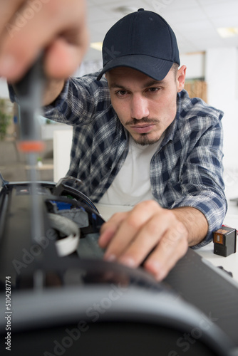 man repairing printerwith a screwdriver