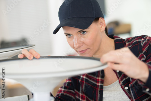female contractor repairing furniture at home
