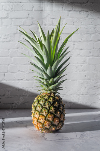 ripe pineapple on white table  background.