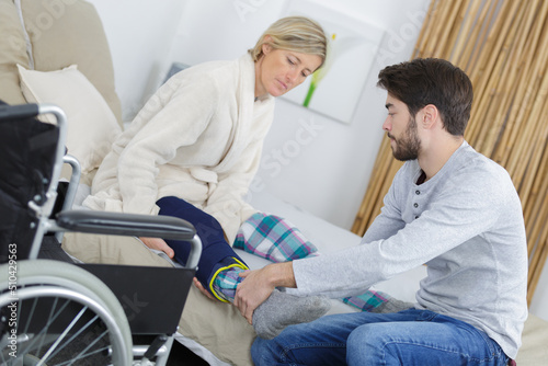 young man helping woman to move injured leg